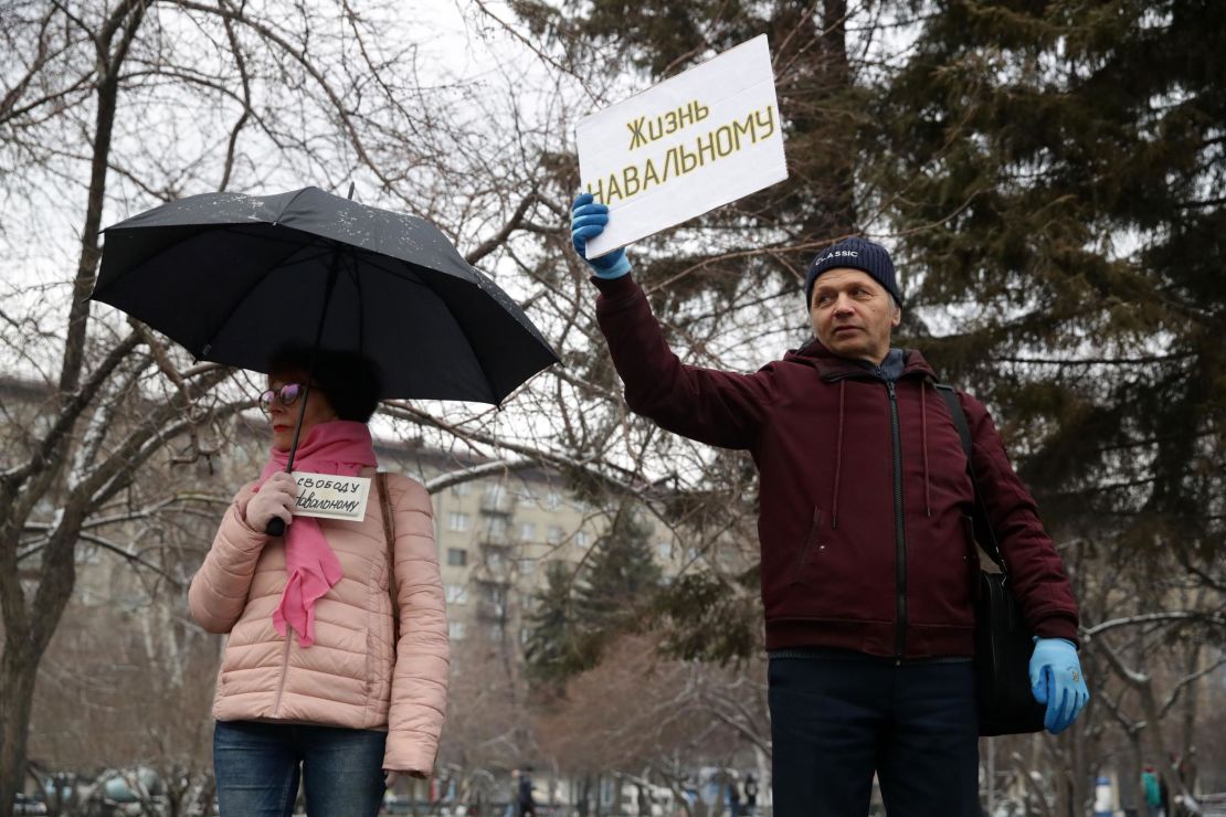 Supporters of Alexey Navalny hold signs reading "Freedom to Navalny" (left) and "Let Navalny Live" as they take part in an unauthorized rally in Lenina Square, Novosibirsk.