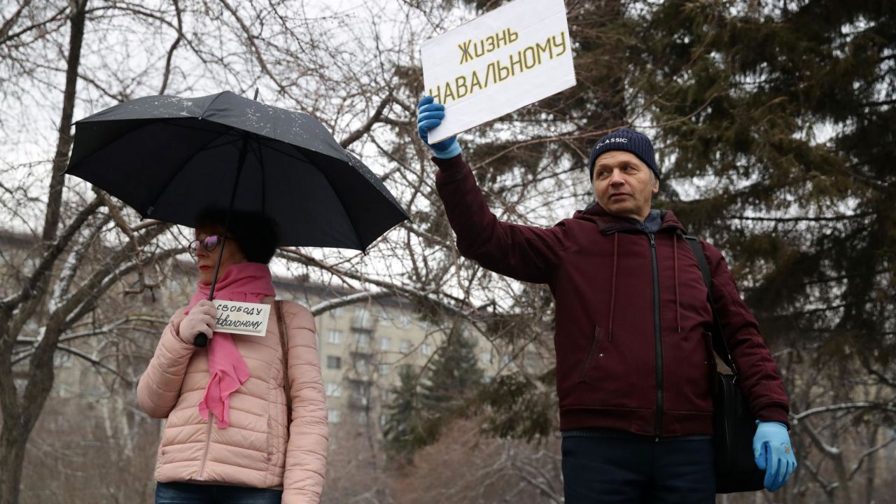 Supporters of Alexey Navalny hold signs reading "Freedom to Navalny" (left) and "Let Navalny Live" as they take part in an unauthorized rally in Lenina Square, Novosibirsk.
