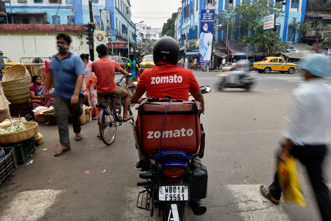 A Zomato delivery rider waits to cross a road in Kolkata, India. 