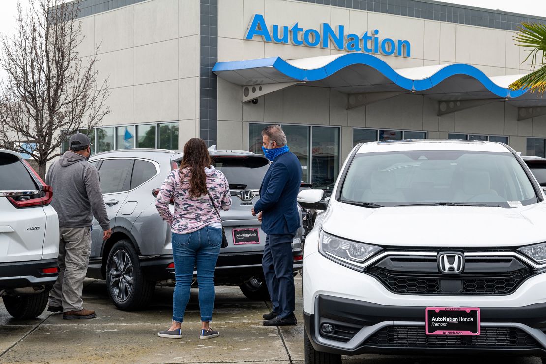 Customers look at cars for sale at an AutoNation dealership in Fremont, California. The company reported record first quarter profits Tuesday that were triple its year-ago earnings.