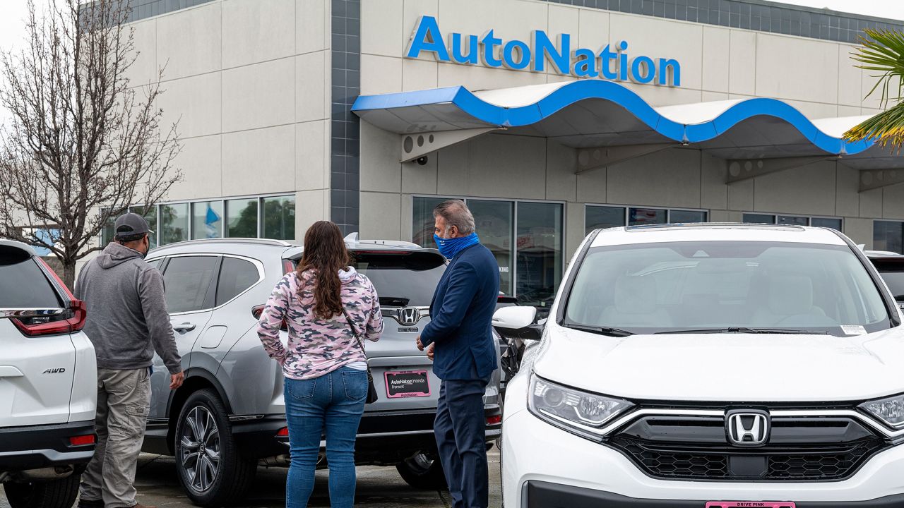 Customers look at cars for sale at an AutoNation dealership in Fremont, California. The company reported record first quarter profits Tuesday that were triple its year-ago earnings.