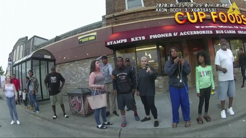 FILE - This May 25, 2020, file image from a police body camera shows bystanders including Alyssa Funari, left filming, Charles McMillan, center left in light colored shorts, Christopher Martin center in gray, Donald Williams, center in black, Genevieve Hansen, fourth from right filming, Darnella Frazier, third from right filming, as former Minneapolis police officer Derek Chauvin was recorded pressing his knee on George Floyd's neck for several minutes in Minneapolis. To the prosecution, the witnesses who watched Floyd's body go still were regular people -- a firefighter, a mixed martial arts fighter, a high school student and her 9-year-old cousin in a T-shirt emblazoned with the word "Love." (Minneapolis Police Department via AP, File)