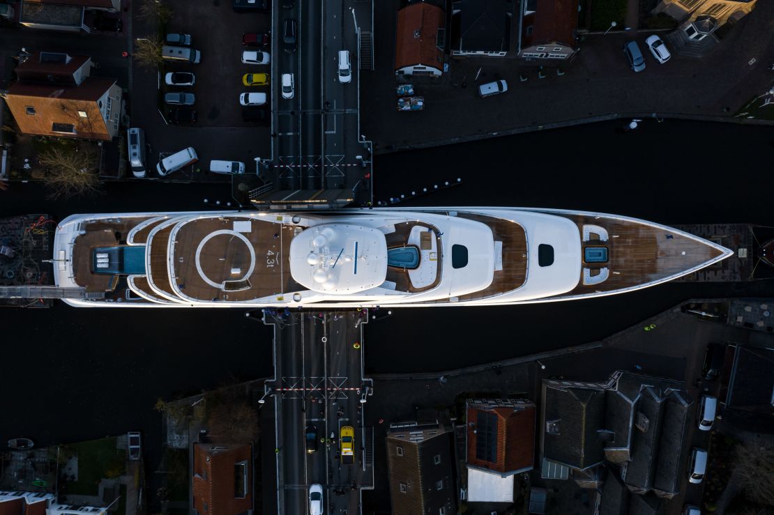 The 94-meter vessel is maneuvered across a bridge in Woubrugge during the tricky journey.