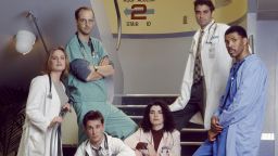 ER -- Season 1 -- Pictured: (standing l-r) Sherry Stringfield as Doctor Susan Lewis, Anthony Edwards as Doctor Mark Greene, George Clooney as Doctor Doug Ross, Eriq La Salle as Doctor Peter Benton (seated l-r) Noah Wyle as Doctor John Carter, Julianna Margulies as Nurse Carlo Hathaway -- Photo by: Chris Haston/NBCU Photo Bank