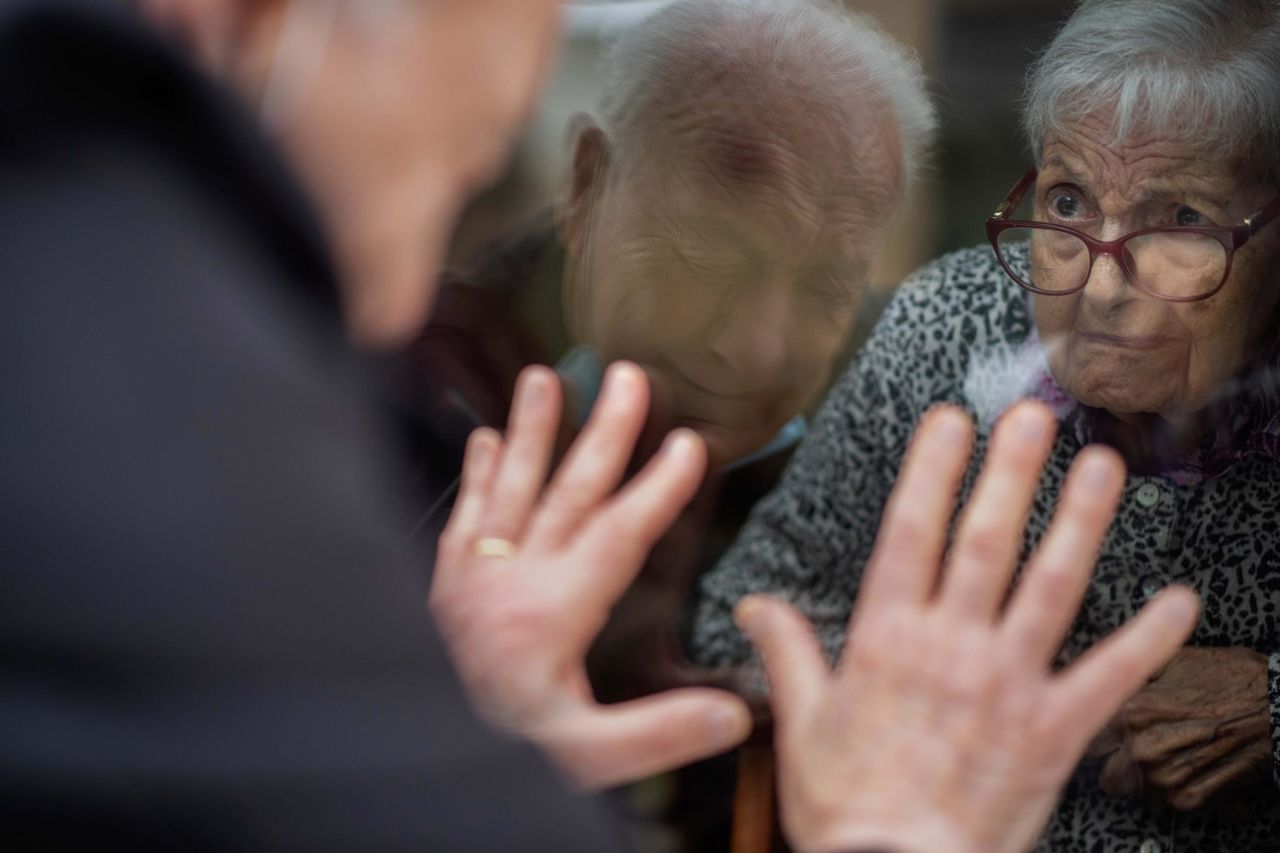 Javier Anto, 90, meets with his wife Carmen Panzano, 92, through the window of her nursing home in Barcelona, Spain, on April 21.