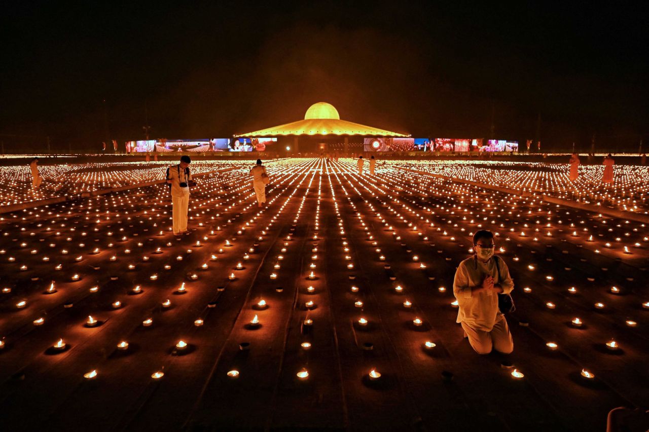 Buddhist monks and devotees take photos with 330,000 candles during an attempt to break the Guinness World Record for the largest flaming image at the Wat Dhammakaya Buddhist temple in Bangkok, Thailand, on April 22.