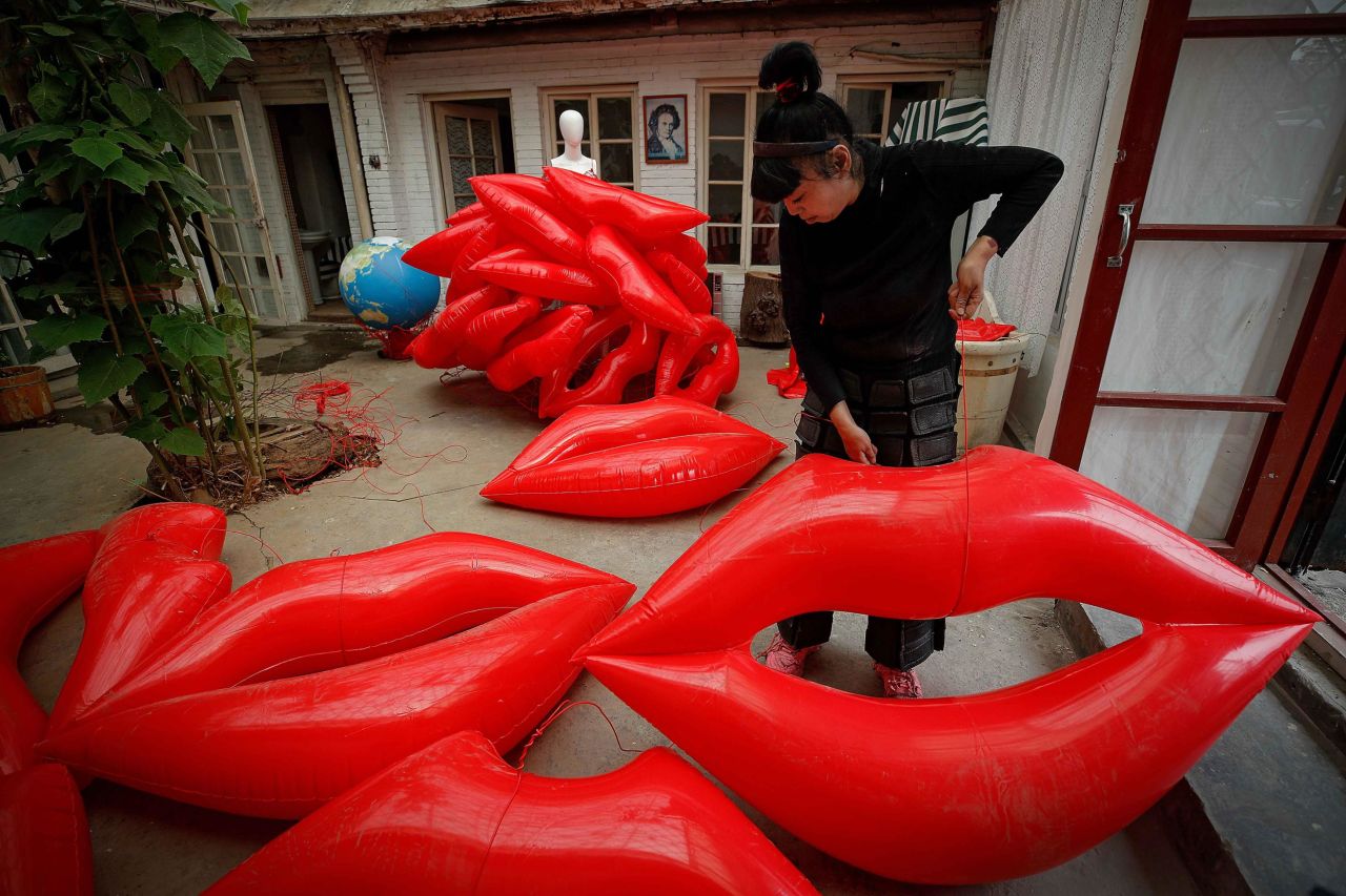 Artist and environmental activist Kong Ning prepares lip-shaped balloons for her latest gown collection, themed "Kiss the Earth," in support of Earth Day on Thursday, April 22, in Beijing. 