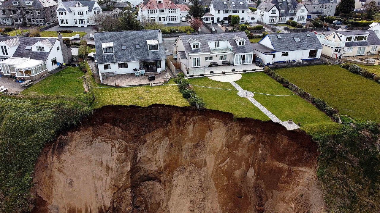 Houses sit on the edge of a cliff after it collapsed in Nefyn, Wales, on Tuesday, April 20.