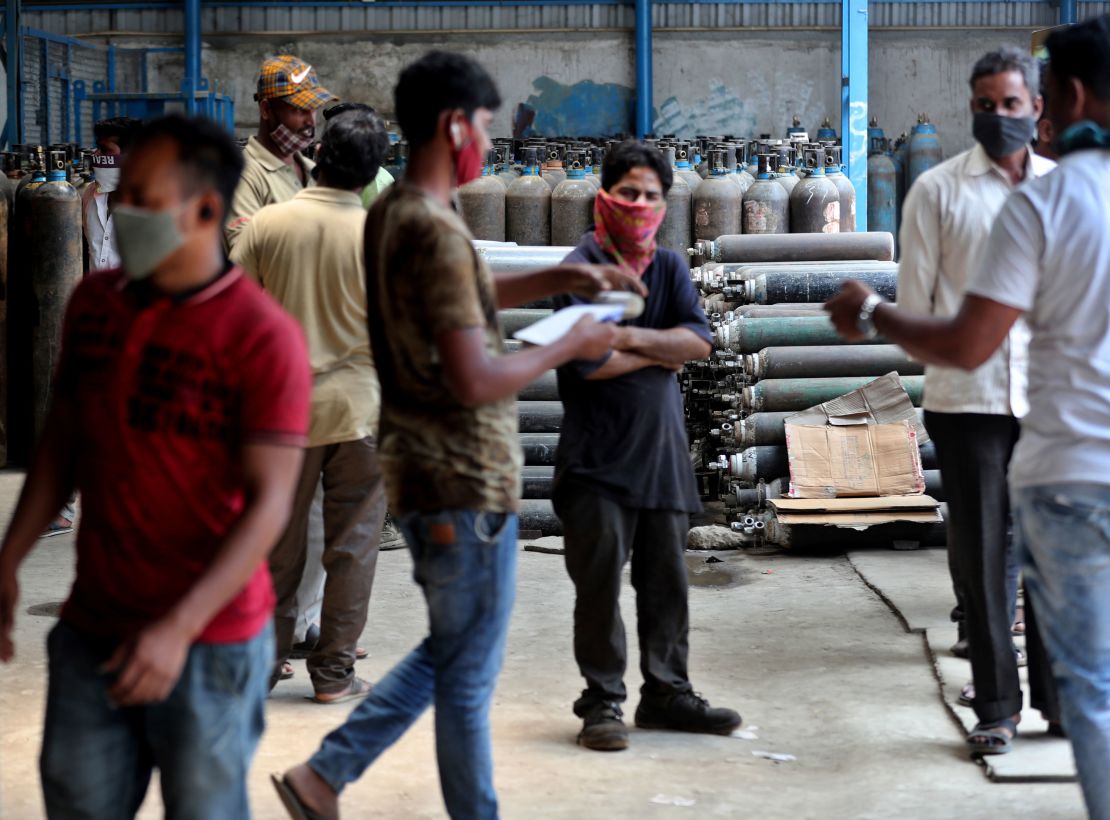 Ambulance drivers and others wait to receive oxygen cylinders at a gas supplier facility in Bengaluru, India, on April 21.