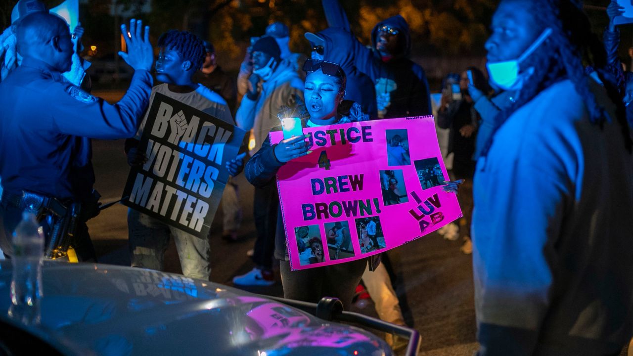 Police try to get  demonstrators to move after they surrounded an Elizabeth City police car on Thursday night.
