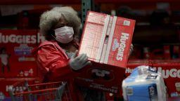 A customer wears a protective mask as she picks up a box of diapers at a Costco store on March 14, 2020 in Novato, California. Some Americans are stocking up on food, toilet paper, water and other items after the World Health Organization (WHO) declared Coronavirus (COVID-19) a pandemic. (Photo by Justin Sullivan/Getty Images)