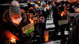 People hold Black Lives Matter signs as they gather during a candlelight vigil to honour Andre Hill's memory outside the Brentnell Community Recreation Center in Columbus, Ohio on December 26, 2020. - The fatal shooting of an unarmed Black man by police in  Columbus, Ohio -- the US city's second such killing this month -- sparked a fresh wave of protests on December 24 against racial injustice and police brutality in the country. Andre Maurice Hill, 47, was in the garage of a house on the night of December 21 when he was shot several times by a police officer who had been called to the scene for a minor incident. (Photo by STEPHEN ZENNER / AFP) (Photo by STEPHEN ZENNER/AFP via Getty Images)