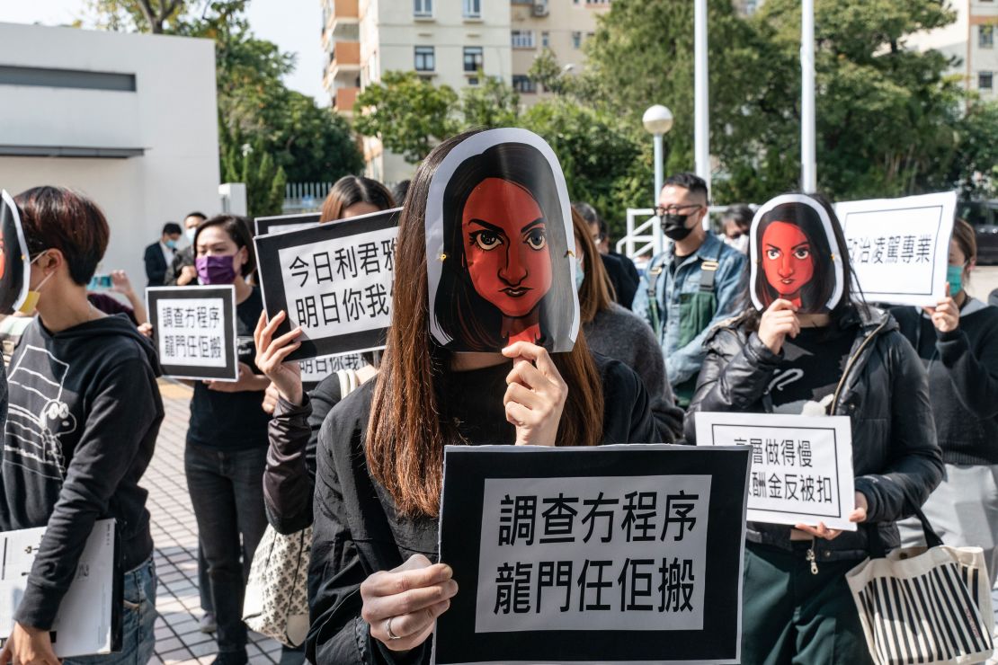 Hong Kong public broadcaster Radio Television Hong Kong (RTHK) staffers wear masks depicting the journalist Nabela Qoser during a silent protest against the management's treatment of her outside Broadcasting House on January 28, 2021 in Hong Kong.