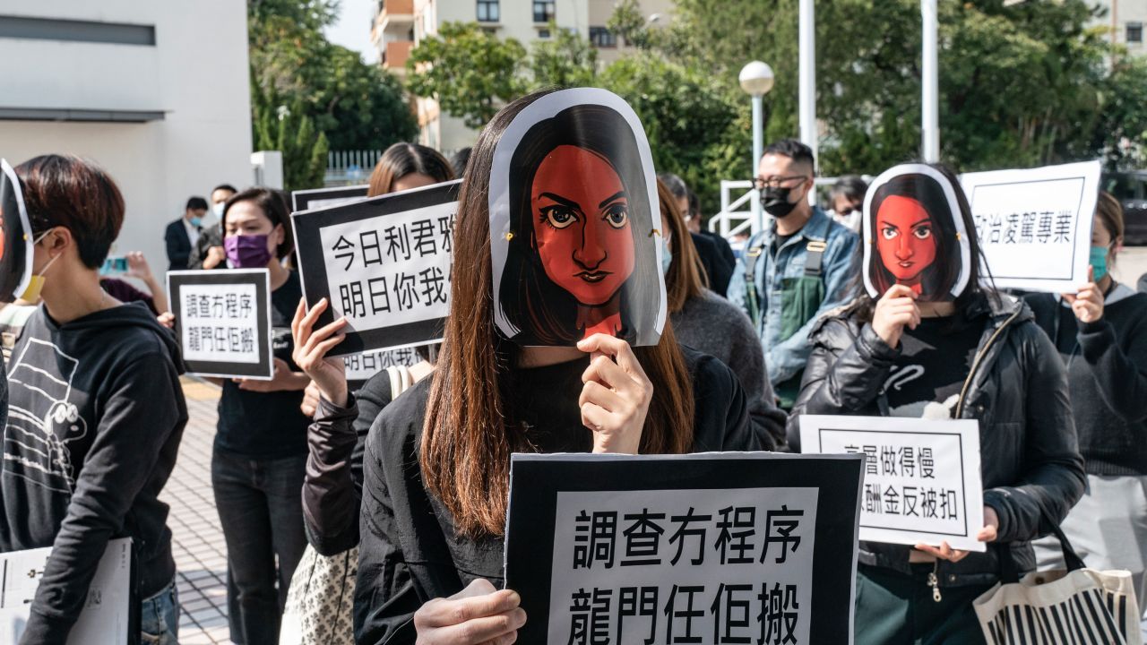 Hong Kong public broadcaster Radio Television Hong Kong (RTHK) staffers wear masks depicting the journalist Nabela Qoser during a silent protest against the management's treatment of her outside Broadcasting House on January 28, 2021 in Hong Kong.