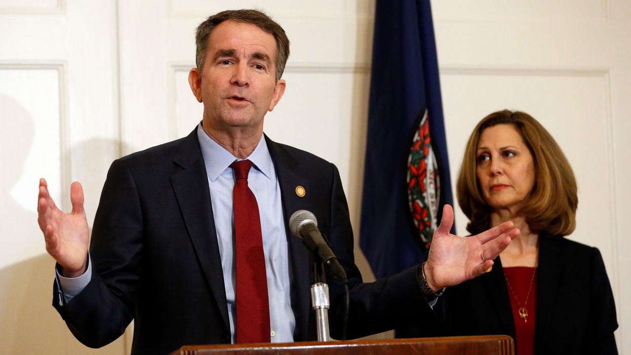 Virginia Gov. Ralph Northam gestures as his wife, Pam, listens during a press conference on February 2, 2019.