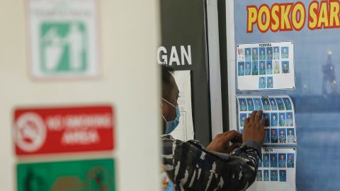 An Indonesian military officer places pictures of the missing crew at Ngurah Rai Military Air Base in Kuta, Bali, Indonesia, on April 23.