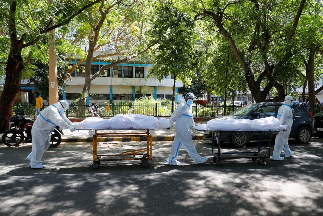 Health workers wearing personal protective equipment  carry bodies of people who were suffering from Covid-19 outside the Guru Teg Bahadur hospital, in New Delhi, India, on April 24.