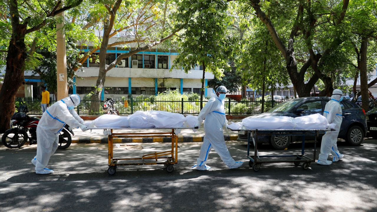 Health workers wearing personal protective equipment  carry bodies of people who were suffering from Covid-19 outside the Guru Teg Bahadur hospital, in New Delhi, India, on April 24.