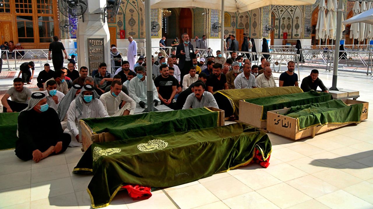 Mourners pray near the coffins of coronavirus patients killed in the hospital fire during their funeral at the Imam Ali shrine in Najaf, Iraq, on Sunday.