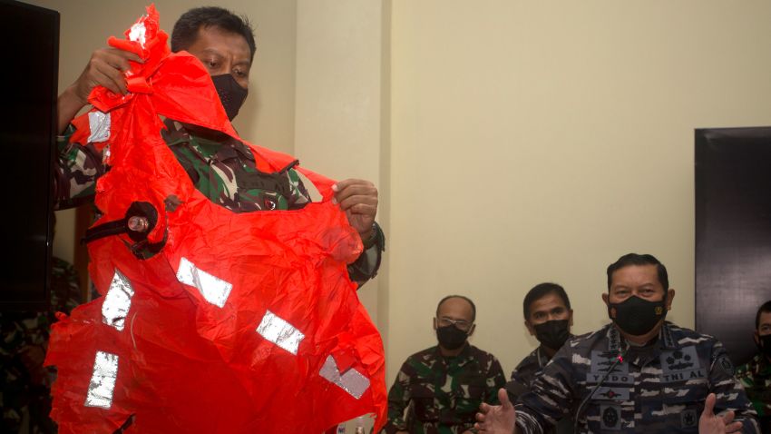 A military officer display a life jacket found in the waters during a search for the Indonesian Navy submarine KRI Nanggala at Ngurah Rai Military Air Base in Bali, Indonesia on Sunday, April 25, 2021. Indonesia's military on Sunday officially admitted there was no hope of finding survivors from the submarine that sank and broke apart last week with 53 crew members aboard, and that search teams had located the vessel's wreckage on the ocean floor. (AP Photo/Firdia Lisnawati)