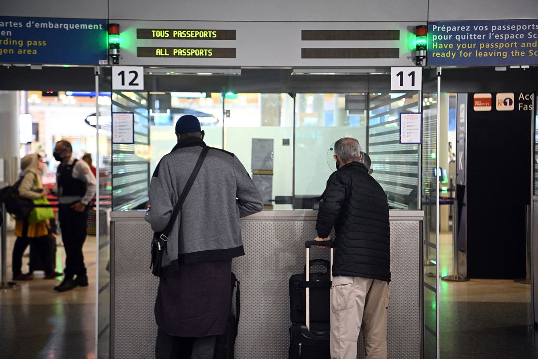 Travellers shows their documents to a border police officer at the immigration desk of Roissy Charles-de-Gaulle international airport, on February 1, 2021.