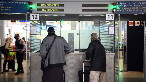 Travellers shows their documents to a border police officer at the immigration desk of Roissy Charles-de-Gaulle international airport, on February 1, 2021.