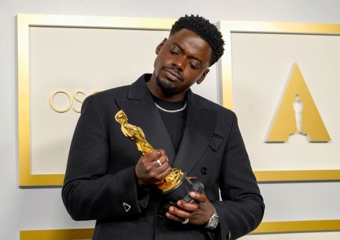 Daniel Kaluuya examines his best supporting actor Oscar, which he won for his role as Black Panther leader Fred Hampton in "Judas and the Black Messiah."