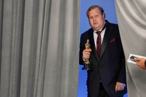 Phillip Bladh, holding the best sound Oscar for "Sound of Metal," enters the press room in Los Angeles.