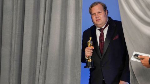Phillip Bladh, holding the best sound Oscar for "Sound of Metal," enters the press room in Los Angeles.