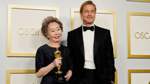 Yuh-jung Youn holds her best supporting actress Oscar as she stands next to presenter Brad Pitt in the press room.