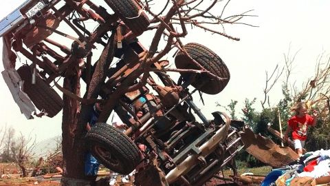 Chealsea Zuchnic, 3, walks past the remains of a truck wrapped around a tree in front of the Zuchnic's destroyed home in Bridge Creek, Okla., on May 4, 1999.