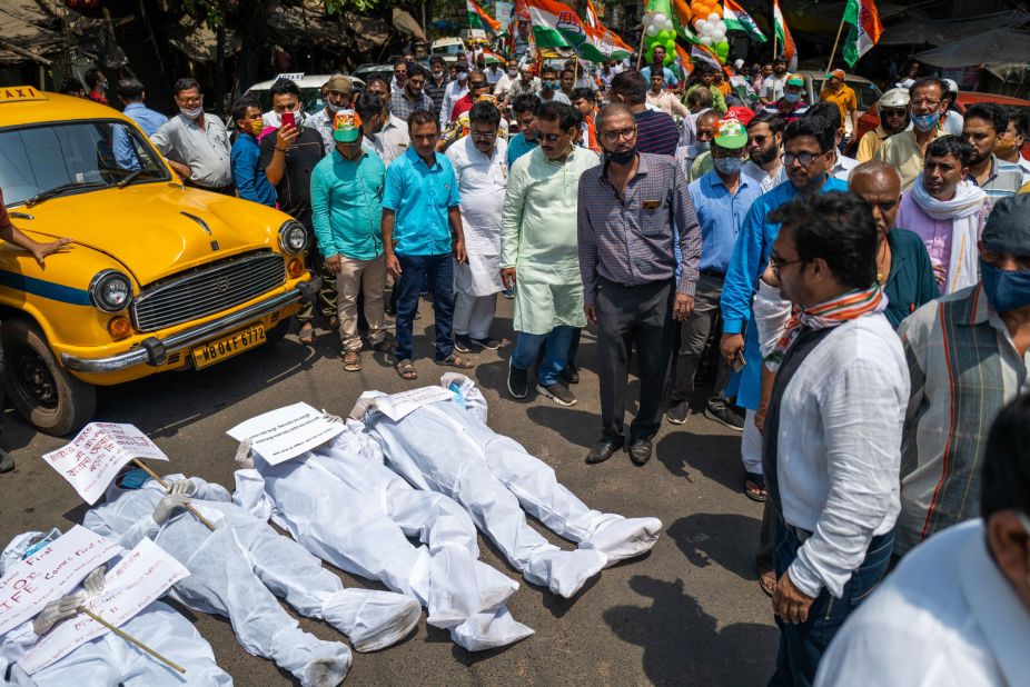 Protesters wearing protective suits lie on a street near the Election Commission office in Kolkata on April 7. They were calling for a stop to the ongoing state legislative election and its associated campaign rallies.