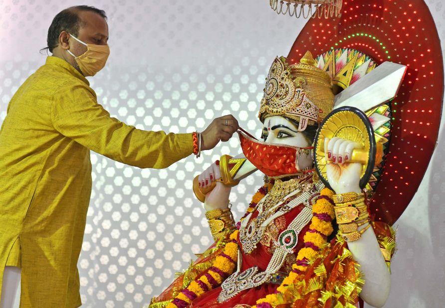 A Hindu priest puts a face mask on an idol of the Goddess Ashapura during Navaratri celebrations in Beawar on April 13.