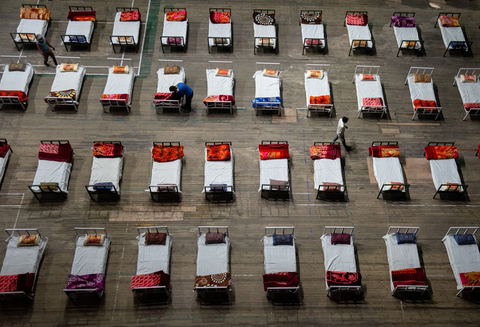 Workers prepare beds for a Covid-19 isolation center that was set up inside a stadium in Srinagar on April 27. 