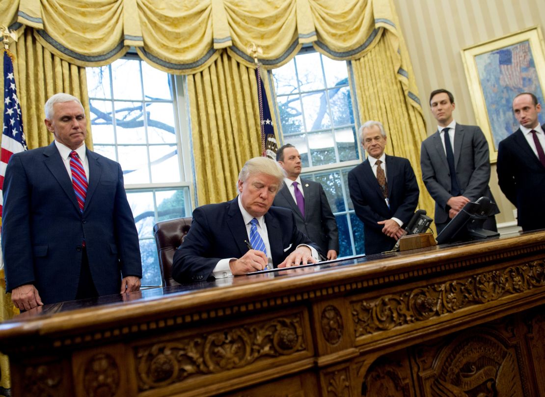 Former President Donald Trump signing an executive order alongside White House officials on January 23, 2017. Among three orders signed was one reinstating and expanding the Mexico City Policy.