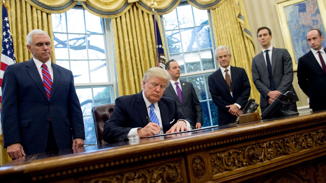 Former President Donald Trump signing an executive order alongside White House officials on January 23, 2017. Among three orders signed was one reinstating and expanding the Mexico City Policy.