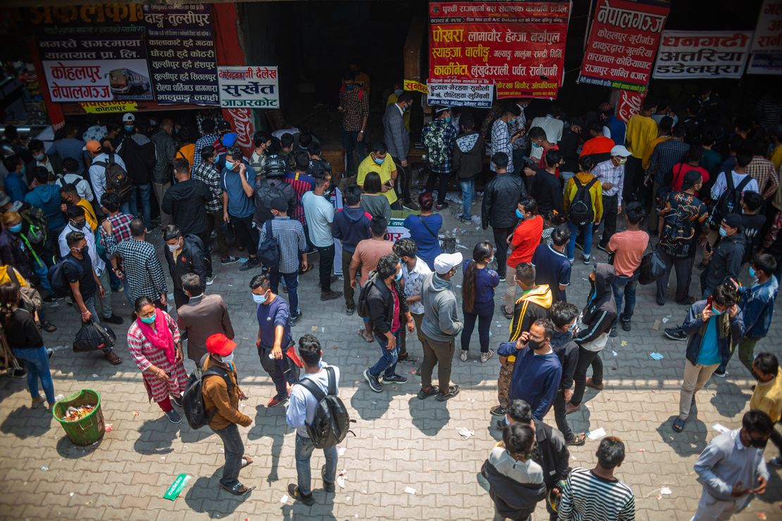 People wait to board a bus back to their home villages after new government restrictions in Kathmandu, Nepal, on April 27.