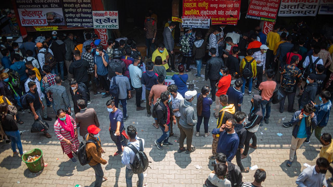 People wait to board a bus back to their home villages after new government restrictions in Kathmandu, Nepal, on April 27.