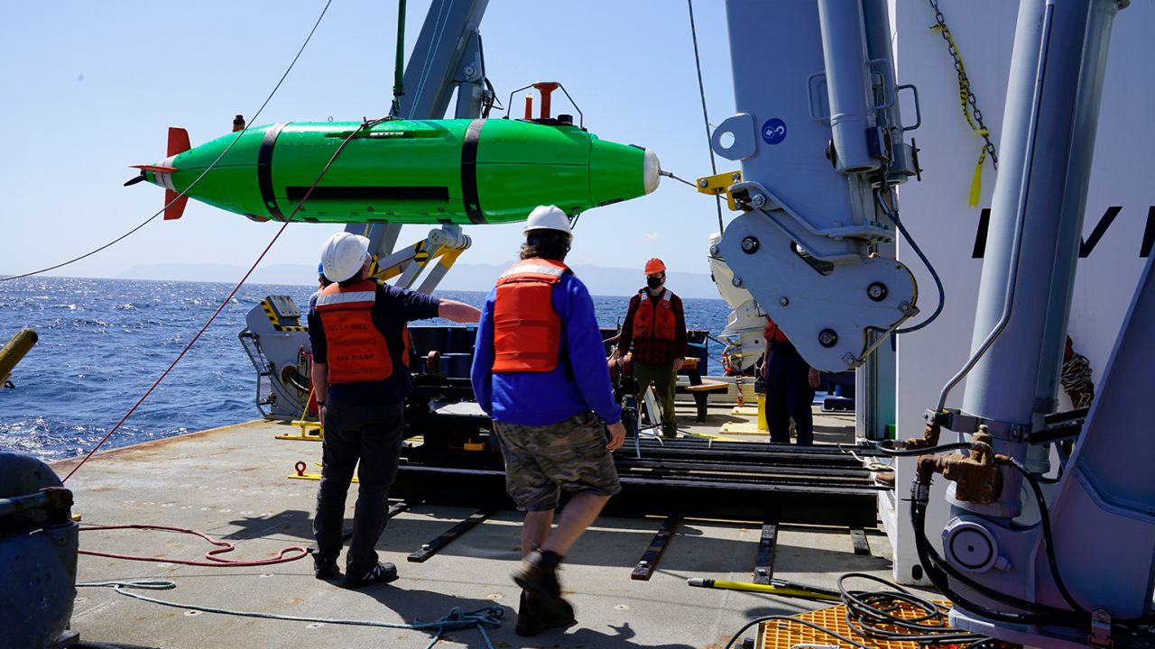 Scripps researchers aboard the Research Vessel Sally Ride recover the REMUS 6000 autonomous underwater vehicle to survey the seafloor. 