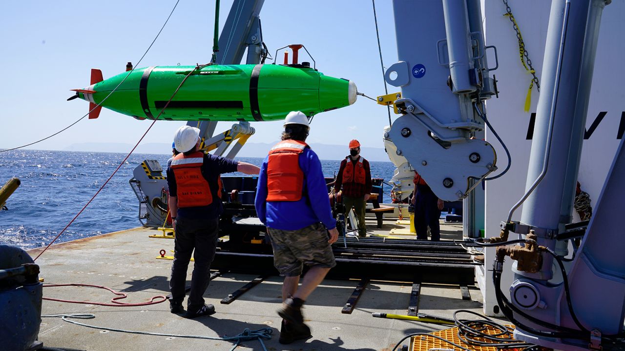 Scripps researchers aboard the Research Vessel Sally Ride recover the REMUS 6000 autonomous underwater vehicle to survey the seafloor.