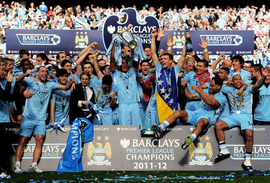 Manchester City players celebrate with the trophy following the Premier League victory in 2011.