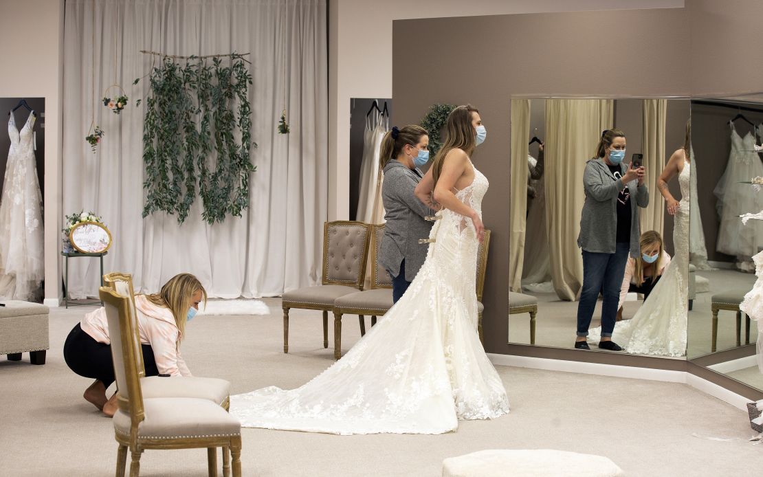 Bride-to-be Taylor Tamling-Thurn gets some assistance from her maid of honor as Tamling-Thurn shops for wedding dresses at Brides & Weddings in Manchester, Iowa, on April 10.