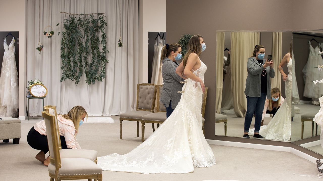 Bride-to-be Taylor Tamling-Thurn gets some assistance from her maid of honor as Tamling-Thurn shops for wedding dresses at Brides & Weddings in Manchester, Iowa, on April 10.