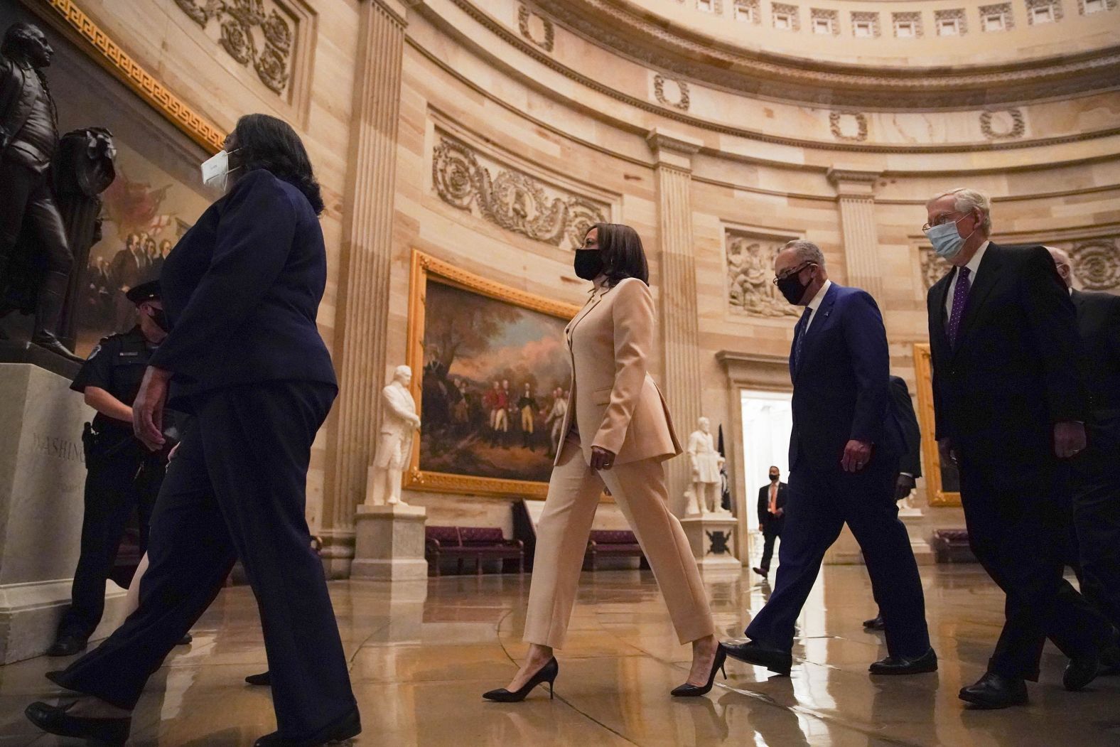 Harris is trailed by Senate Minority Leader Chuck Schumer and Senate Minority Leader Mitch McConnell as they walk through the Capitol Rotunda before the speech.