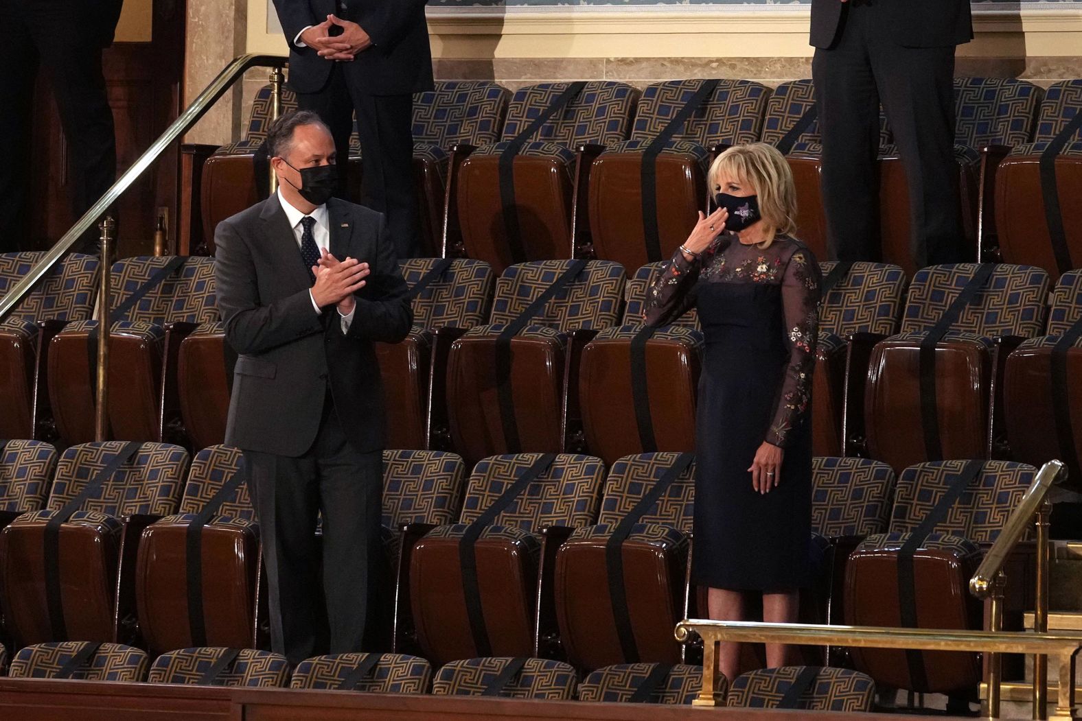 First lady Jill Biden, next to second gentleman Doug Emhoff, gestures to her husband at the beginning of the speech.