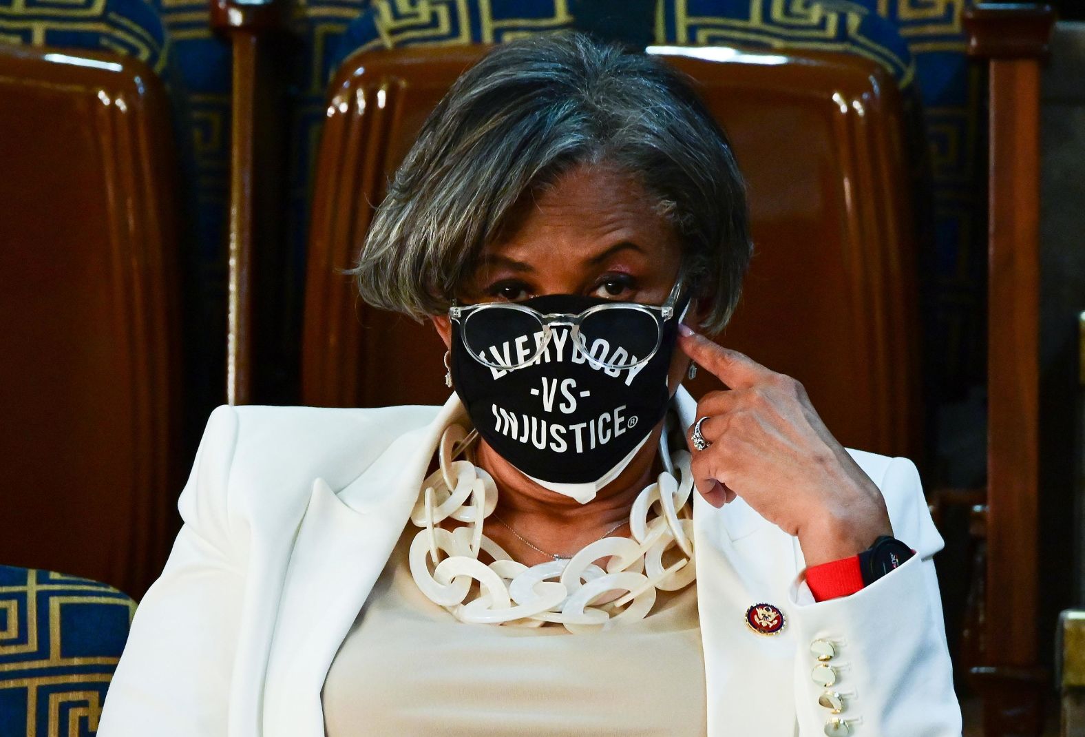 US Rep. Brenda Lawrence wears a mask that says "everybody vs. injustice" as she waits for Biden's speech.