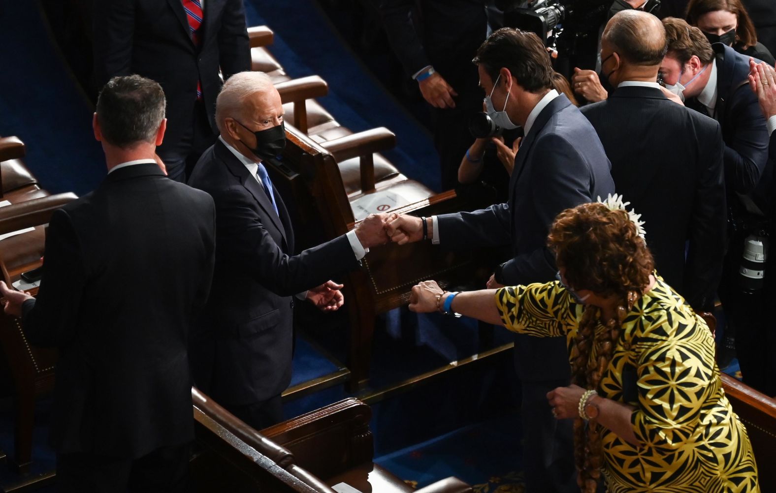 Biden greets people as he arrives in the House chamber.
