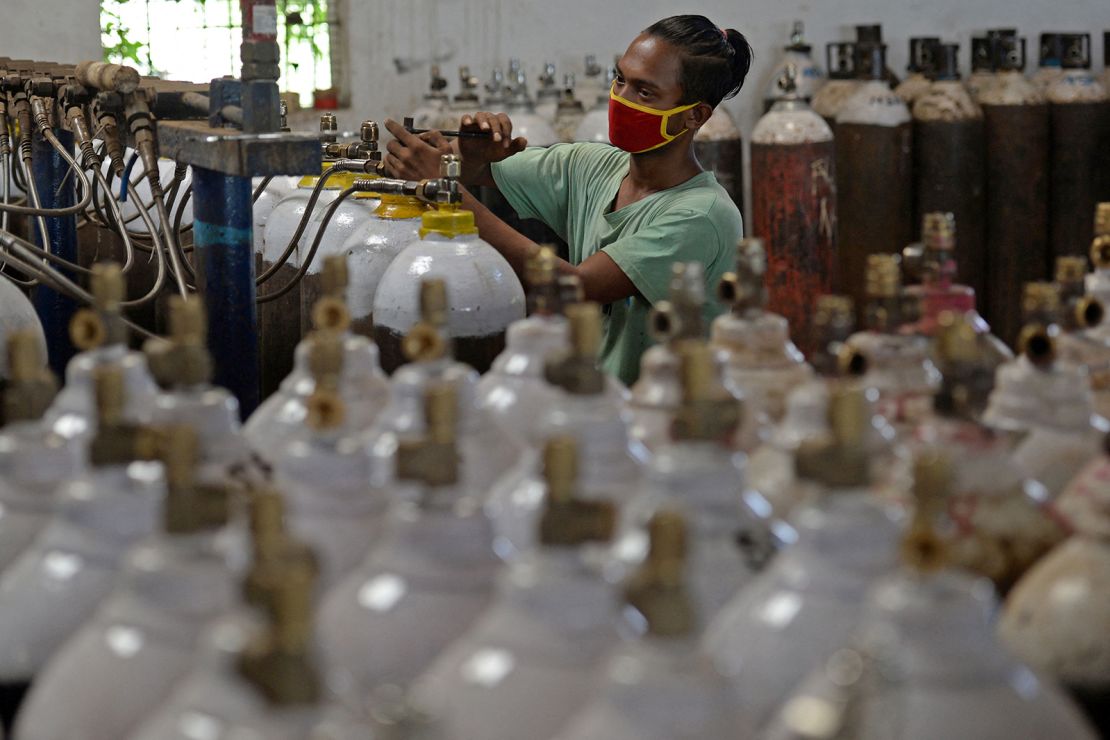 A worker fills medical oxygen cylinders on the outskirts of Chennai.