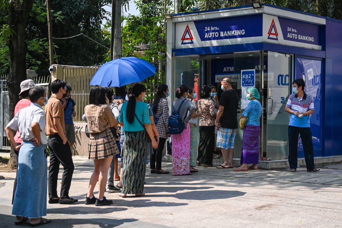 People queue as they wait to use the ATM in Yangon on April 7, 2021, amid strained banking operations due to the military coup. 