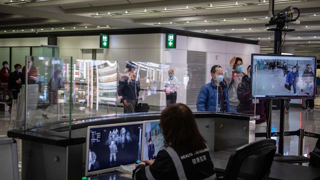 Airport health staff monitor the body temperatures of arriving passengers with thermal scanners in an arrival hall inside Hong Kong International Airport on February 21, 2020.